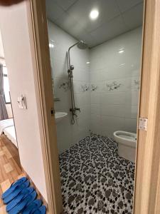 a bathroom with a shower and a tub and a toilet at Hotel Trang Huy in Thuan An