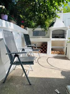 two chairs sitting on a patio next to a grill at Souterrain 2 Zimmer Wohnung Freiburg Seepark in Freiburg im Breisgau