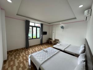a room with two beds and a window at Hotel Trang Huy in Thuan An