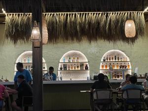 um grupo de pessoas sentadas num bar num restaurante em Front Samet Beach house with swimming Pool em Rayong