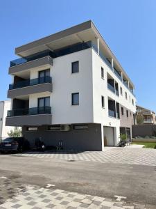 um edifício branco com um parque de estacionamento em frente em Villa 64 Apartment #3 em Mlini