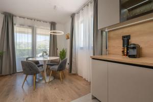 eine Küche und ein Esszimmer mit einem Tisch und Stühlen in der Unterkunft Villa 64 Apartment #3 in Mlini