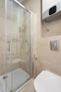 La salle de bains est pourvue d'une douche en verre et de toilettes. dans l'établissement Villa 64 Apartment #3, à Mlini