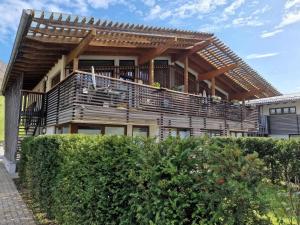 a house with a large balcony with a deck at Modern apartment with Wilder Kaiser view in Kirchdorf in Tirol