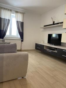 a living room with a couch and a flat screen tv at Apartment Svemir in Primošten