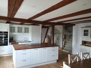 a large kitchen with white cabinets and a table at 3 Bedroom Swiss House on 3 Floors in Oberglatt