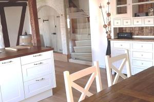 a kitchen with white cabinets and a table and chairs at 3 Bedroom Swiss House on 3 Floors in Oberglatt