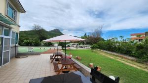 a patio with a picnic table and an umbrella at 尖山沐氧 Jianshan Bathe Oxygen in Kenting