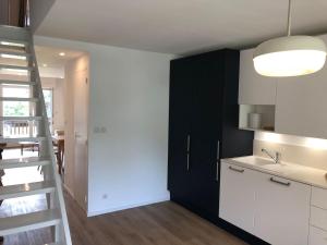 a kitchen with black and white cabinets and a ladder at Appartement plein centre cap ferret in Lège-Cap-Ferret +5 photos