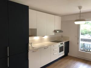 a kitchen with white cabinets and a sink and a window at Appartement plein centre cap ferret in Lège-Cap-Ferret