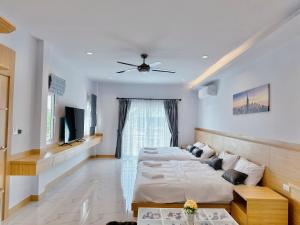 a bedroom with two beds and a ceiling fan at Rosewood Pool Villa Pattaya 3 in Pattaya South