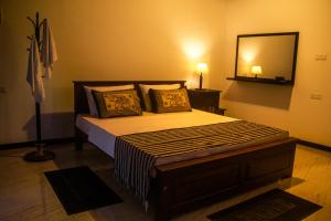 a bedroom with a large bed with a large mirror at Oragan Resort in Tissamaharama