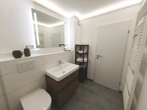 a bathroom with a sink and a toilet and a mirror at Strandapartment-Kalifornien in Kalifornien