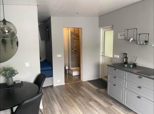 a kitchen with a table and a sink and a bathroom at Cosy lakeview cabin 45 minutes from Reykjavik in Mosfellsbær