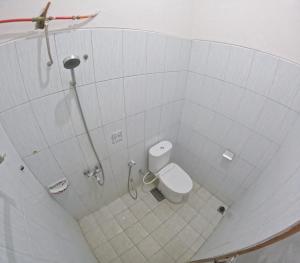 a white bathroom with a toilet and a shower at Mendiro Griya Syariah in Ngemplak +11 photos