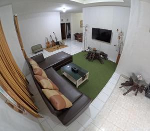 - un salon avec un canapé et une télévision dans l'établissement Mendiro Griya Syariah, à Ngemplak