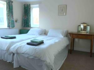 a bedroom with a white bed with two towels on it at Ivy cottage in West Mersea