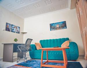 ein Wohnzimmer mit einem blauen Sofa und einem Tisch in der Unterkunft Zuriel Homes 1 Bedroom apartment in Kakamega