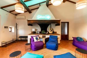 d'un salon avec des fauteuils violets et bleus et une cheminée. dans l'établissement Selvuccia Lodge - Ostello Agricolo, à San Piero a Sieve