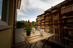 a wooden table on a balcony with flowers on it at B&B Roma 474 in Rome