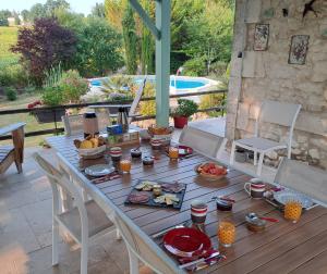 een tafel met eten op een patio bij Chambres d'hôtes Le Muguet in Mandacou