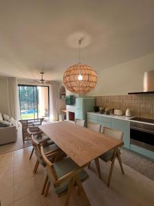 cocina y comedor con mesa de madera y sillas en Villa Alvor piscina praia e golf, en Alvor