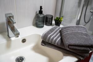a bathroom sink with two towels and a shower at Stunning new apartment in centre of Buzet in Buzet