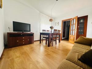 a living room with a couch and a table with a television at Cal Boix in Tremp