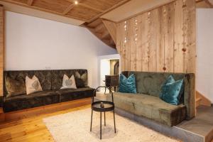 a living room with two couches and a table at Fürthermoar Hideaways in Kaprun