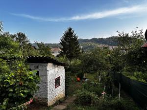 ein Steinhaus in einem Garten mit einem Zaun in der Unterkunft Apartment Ollie Tuzla in Tuzla