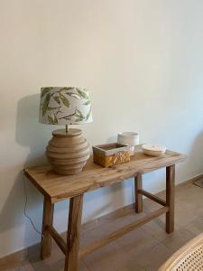 une table avec une lampe et un vase sur elle dans l'établissement Villa Alvor piscina praia e golf, à Alvor