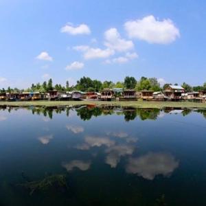 une grande masse d'eau avec un groupe de maisons dans l'établissement Green view group of houseboats, à Srinagar