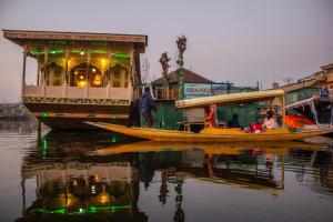 Un bateau dans l'eau avec des gens sur lui dans l'établissement Houseboat New Manora, à Srinagar