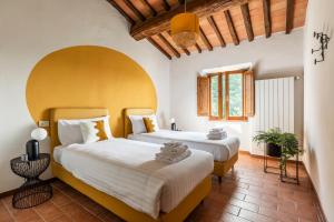 a bedroom with two beds and a wooden ceiling at Selvuccia Lodge - Ostello Agricolo in San Piero a Sieve