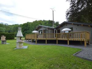 ein Haus mit einer Terrasse mit Sonnenschirmen darauf in der Unterkunft Scenic chalet in Vieuxville with terrace in Vieuxville