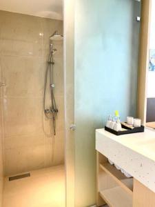 uma casa de banho com um chuveiro, um lavatório e um balcão em Cam Ranh Nha Trang Seaview Resort em Cam Ranh