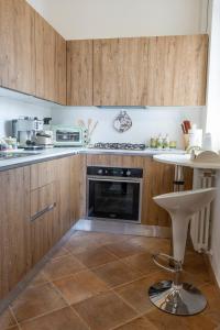 cocina con armarios de madera y horno con fogones en Casa Vacanze La Perla del Lago, en Passignano sul Trasimeno