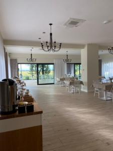 a large room with tables and chairs and a dining room at Willa Polanka in Gościno