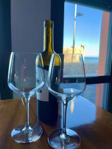 due bicchieri da vino seduti su un tavolo con una bottiglia di vino di Casa La Calma a Las Palmas de Gran Canaria