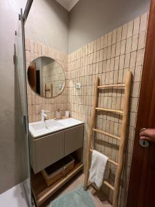 La salle de bains est pourvue d'un lavabo et d'un miroir. dans l'établissement Villa Alvor piscina praia e golf, à Alvor