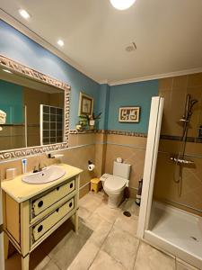 a bathroom with a sink and a toilet and a mirror at Casa La Calma in Las Palmas de Gran Canaria