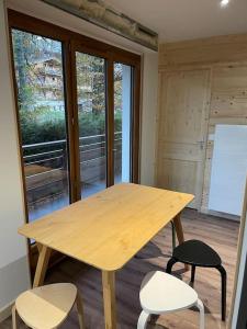 a wooden table and chairs in a room at Très beau T1 refait à neuf in Les Gets