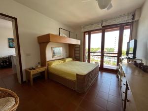 una camera con letto e balcone di Ampio appartamento in centro con terrazze e parcheggio gratuito a Lignano Sabbiadoro