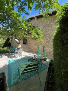 a group of chairs and tables on a patio at Maison au pied de la Roche in Solutré-Pouilly +2 photos
