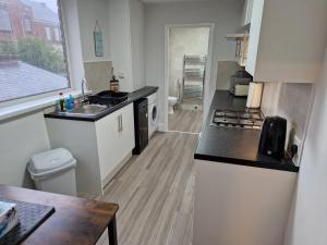 a kitchen with a sink and a counter top at Birtley's Diamond 3 bed Apt, sleeps 6 Guests in Birtley