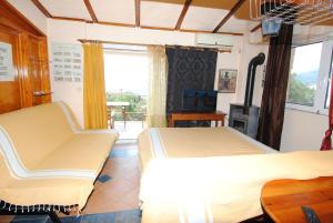 a bedroom with two beds and a chair and a window at Villa Sofia in Marmari +121 photos