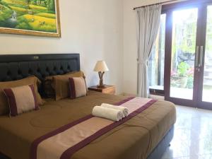 a bedroom with a large bed with a towel on it at Surya Guest House Sanur in Sanur