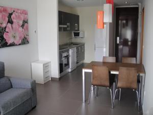 a kitchen and dining room with a table and chairs at Aparthotel El Faro in Cullera