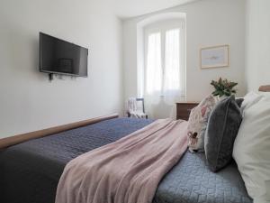 a bedroom with a bed with a tv on the wall at La Malva - L'Opera Group in La Spezia