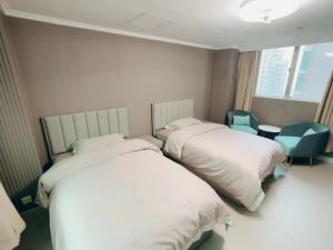 a room with two beds and a chair at 皇后超級管家 in Hong Kong